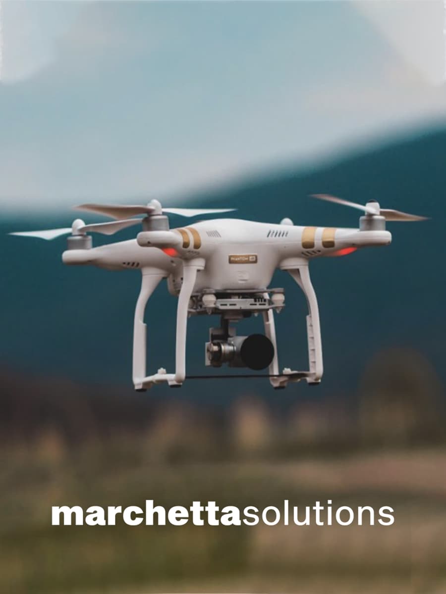 Marchetta Solutions indagini con droni per l'edilizia, drone bianco in volo dotato di una telecamera per compiere le rilevazioni